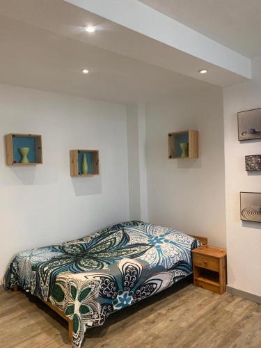 - une chambre avec un lit et une couette à motifs dans l'établissement Studio 24m2 intra-muros, à Avignon