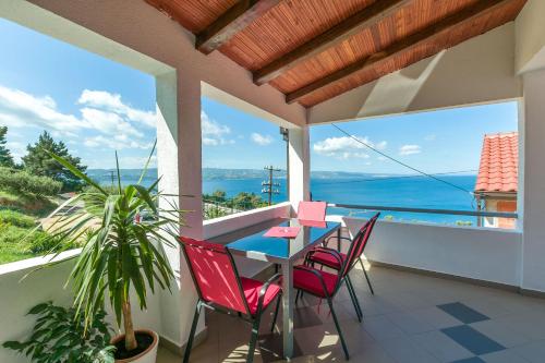 a table and chairs on a balcony with a view of the ocean at Apartment Josipa in Omiš