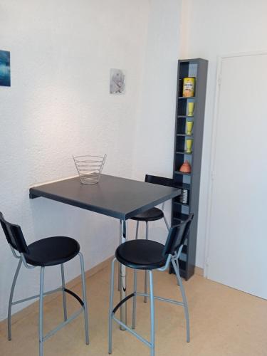 une table et quatre chaises dans une pièce dans l'établissement Studio - Marina 6 - 35 allée des Pinons - 3-1, à Saint-Jean-de-Monts