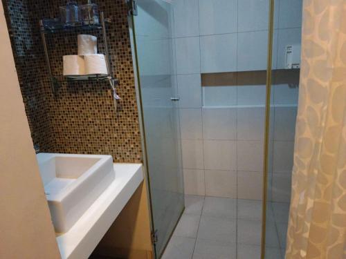 a bathroom with a sink and a glass shower at Pico Beach Front Condo in Nasugbu