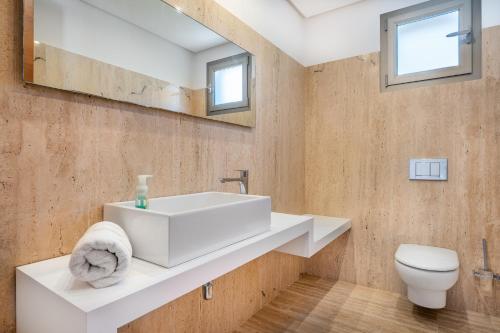 a bathroom with a white sink and a toilet at Villa Ullastre in Manacor