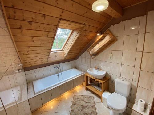 a bathroom with a tub and a toilet and a sink at Dom w Puszczy Augustowskiej in Płaska