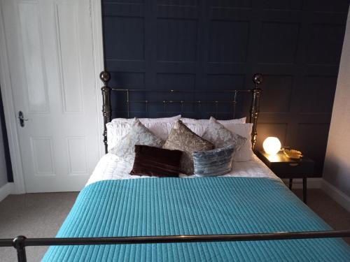 a bedroom with a bed with blue sheets and pillows at On Yer Bike & Gone Fishin in Millport