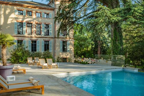 a house with a swimming pool in front of a building at Château de Fiac - Luxurious Hôtel & Spa in Fiac