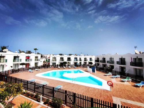 a large swimming pool in front of some buildings at CorralejoDunas piscinas wifi tenis bicicletas, by Momi Fuerteventura in Corralejo