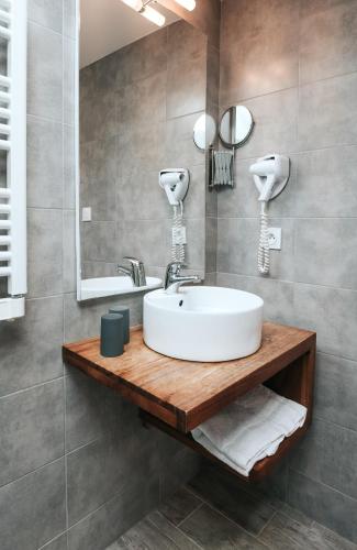 a bathroom with a sink and a mirror at Hôtel Aux Tamaris - Vue Mer in Roscoff
