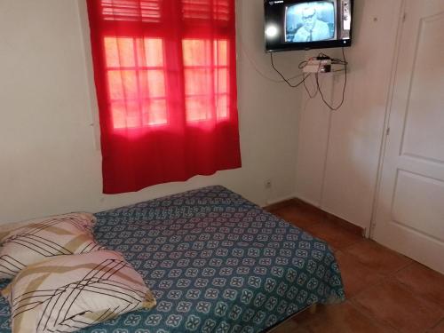 a bedroom with a bed and a tv in a room at LE DIAMANT Charmante Villa pour la famille ou entre amis SPA et Piscine in Le Diamant