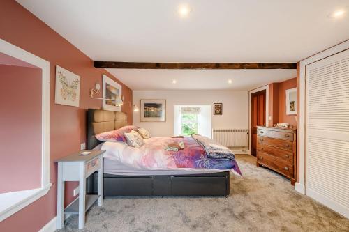 a bedroom with a large bed and a dresser in it at Smithy House in Lochgilphead