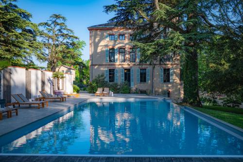 a swimming pool in front of a building at Château de Fiac - Luxurious Hôtel & Spa in Fiac