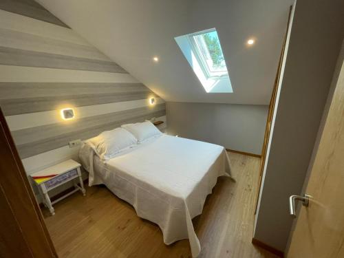 1 dormitorio con cama blanca y ventana en Casa y Apartamento Rural Terra Celta en Salceda de Caselas, en Salceda