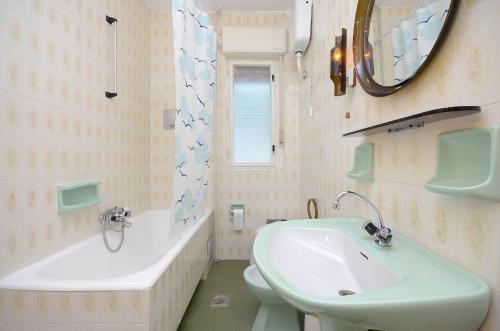 a bathroom with a sink and a tub and a toilet at Apartments Mladen Jelica in Ičići