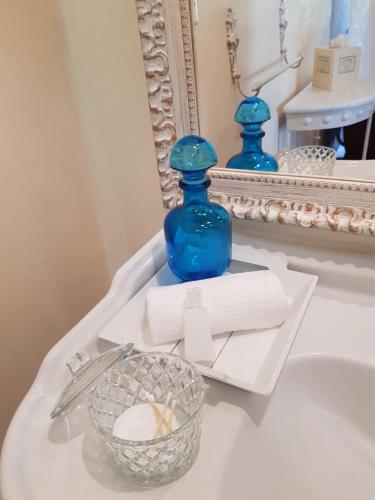 Una botella azul en la parte superior del lavabo del baño en Le clos du Mûrier en Fongrave