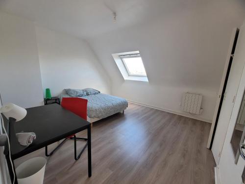 - une chambre avec un lit, un bureau et une fenêtre dans l'établissement Maison de ville avec 4 grandes chambres, à Brest