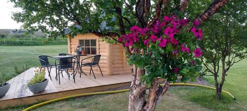 eine Terrasse mit einem Tisch und einem Baum mit rosa Blumen in der Unterkunft Varjjatgeainu Apartment Nesseby in Varangerbotn