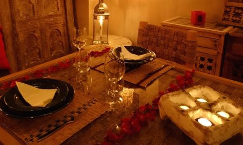 a table with wine glasses and a plate of food at L'Ma Lodge in Skoura