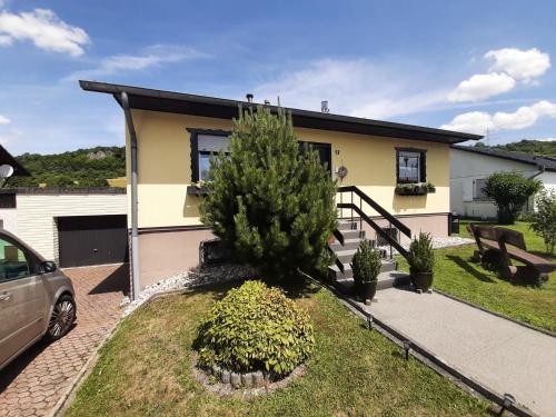 a house with a tree in front of it at Ferienhaus Schwalbennest in Gerolstein