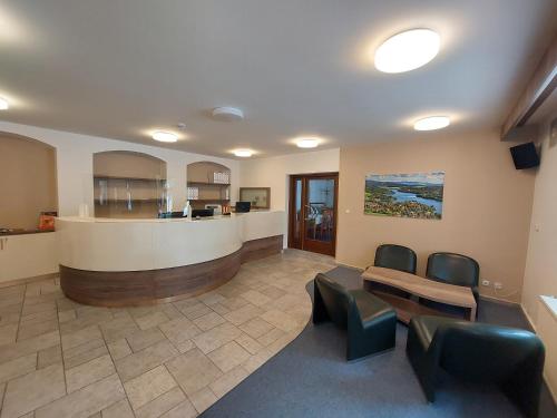 a waiting area in a hospital with chairs and a bar at Hotel Vltava in Frymburk