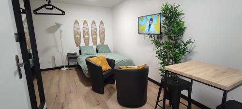 - un salon avec un lit, une table et une table dans l'établissement **Studio Holidays** Centre ville 20 m2, à Châlons-en-Champagne