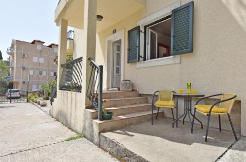 a patio with a table and chairs outside of a house at Apartments and Rooms Iva in Petrovac na Moru