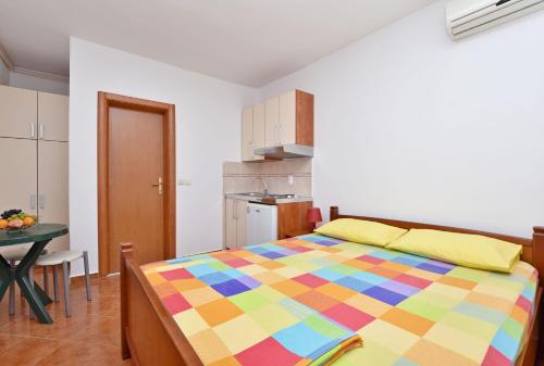 a bedroom with a colorful bed and a table at Apartments and Rooms Iva in Petrovac na Moru