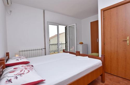 a bedroom with a bed and a balcony at Apartments and Rooms Iva in Petrovac na Moru