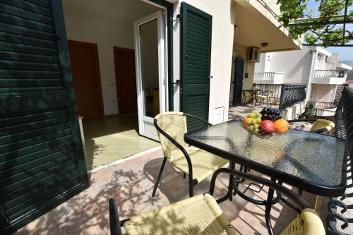 a table with a bowl of fruit on a balcony at Apartments and Rooms Iva in Petrovac na Moru