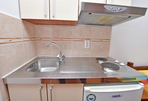 a kitchen with a sink and a stove at Apartments and Rooms Iva in Petrovac na Moru