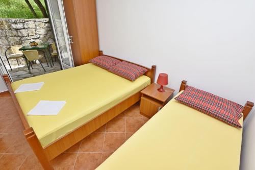 two twin beds in a room with a balcony at Apartments and Rooms Iva in Petrovac na Moru