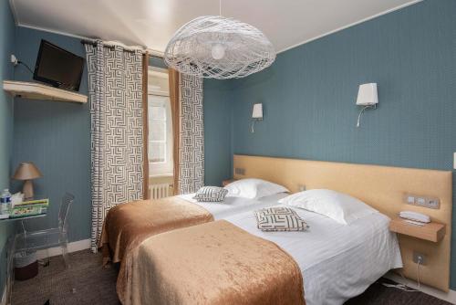 een slaapkamer met 2 bedden en een blauwe muur bij Logis Auberge De La Sélune in Ducey