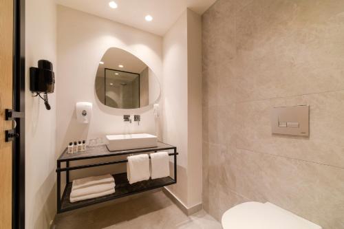 a bathroom with a sink and a mirror at Sol Cosmopolitan Rhodes in Ixia