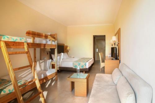 a living room with a couch and bunk beds at Sol Cosmopolitan Rhodes in Ixia