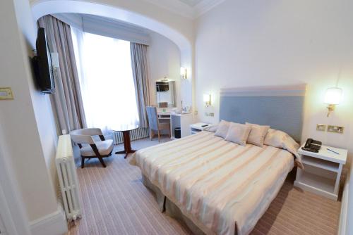 a hotel room with a large bed and a desk at Burlington Hotel, BW Premier Collection by Best Western in Folkestone