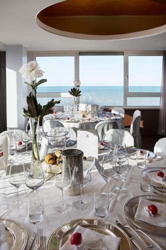 a table with wine glasses and flowers on it at City Hotel in Senigallia