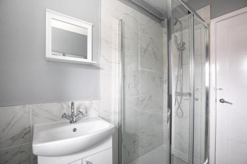 biała łazienka z umywalką i prysznicem w obiekcie Central & Contractors & Leisure House & Spacious w mieście Lincolnshire