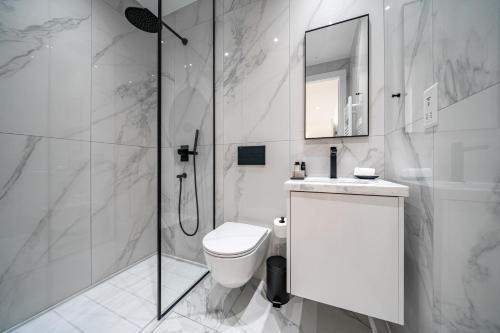 uma casa de banho branca com um WC e um chuveiro em The Palmiers em Pafos