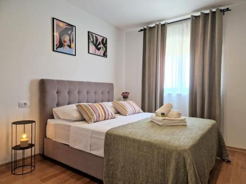 a bedroom with a bed with a table and a window at Jazz Rooms and Apartments in Rovinj