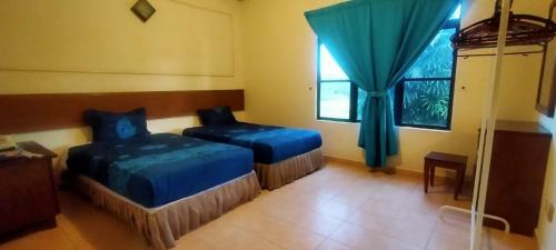 a bedroom with two beds and a window at SHA GATHERING ALOR GAJAH BUNGALOW, A FAMOSA MELAKA in Melaka
