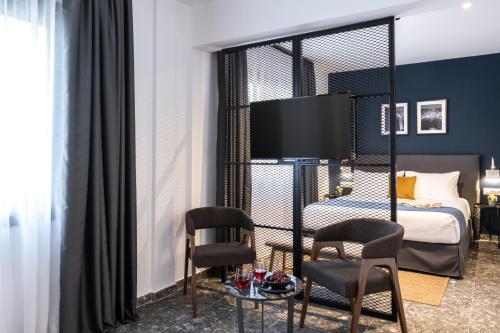 a hotel room with a bed and two chairs at Play Theatrou Athens in Athens