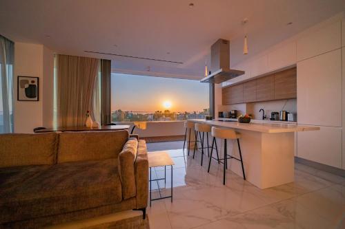 a living room and kitchen with a couch and a counter at The Palmiers in Paphos City