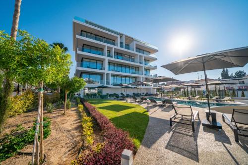 a hotel with a pool and chairs and an umbrella at The Palmiers in Paphos City