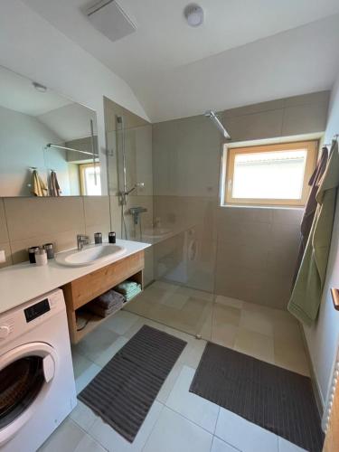 ein Badezimmer mit einer Waschmaschine und einem Waschbecken in der Unterkunft Das Haus am Anger in Breitenbrunn
