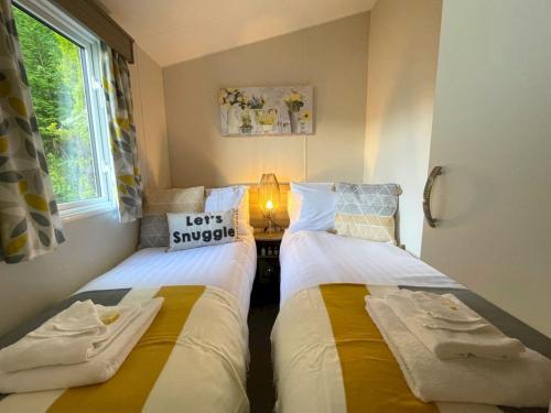 two beds sitting next to each other in a room at Pass the Keys Beautiful 3BR Holiday Home in Stunning Location in Moffat