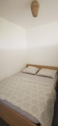 a bed in a room with two pillows on it at Spacieux studio Perols in Pérols