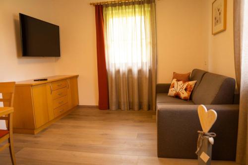 a living room with a couch and a flat screen tv at Anewandterhof in Brunico