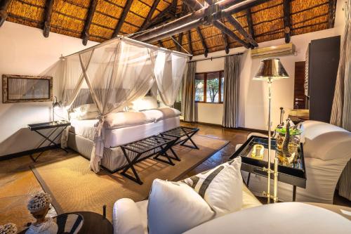 a bedroom with a bed with a mosquito net at Mushara Lodge in Namutoni