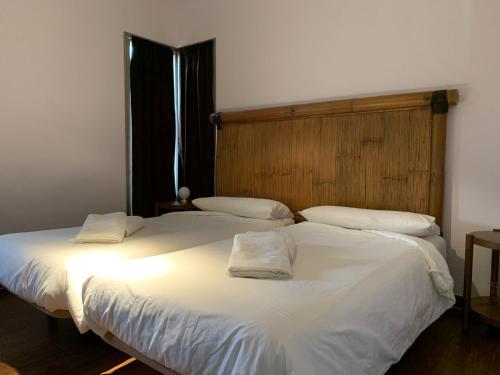 2 bedden in een slaapkamer met witte lakens en kussens bij Casa 110 in Aldea del Fresno
