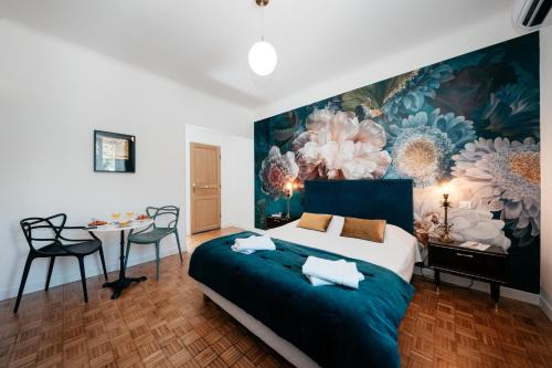 Les Précieuses Suites & Spa II في أفينيون: غرفة نوم بسرير كبير عليها لوحة على الحائط