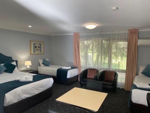 a hotel room with two beds and a window at Town & Country Motor Inn in Forbes