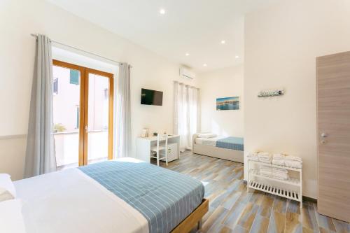 a white bedroom with a bed and a window at Lo Scuncino in Procida