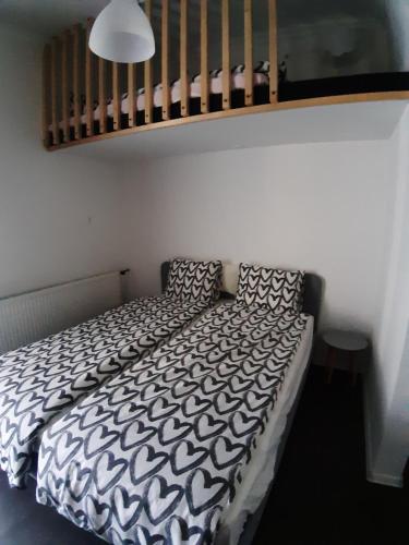 a bedroom with a bed with a black and white comforter at MY WAY BB in Bag